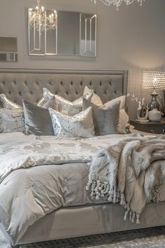 a bedroom with a bed, chandelier and pillows