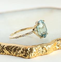 a gold ring with an aqua topazte and diamond accents