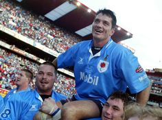 a rugby player is sitting on the shoulders of his team mates