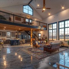 a large open living room with high ceilings and lots of windows on the second floor