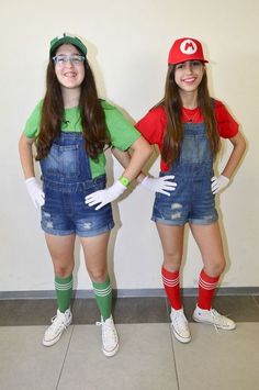 two girls dressed up as mario and luigi from mario bros are standing in front of a wall