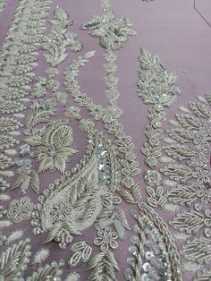 an embroidered fabric with sequins and beads is shown on a tablecloth,