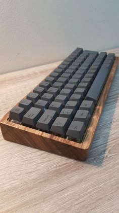 a computer keyboard sitting on top of a wooden table