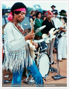 a man playing guitar in front of a group of people