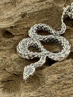 A nice little snake pendant may fill a hole in your jewelry collection. This one has really clear scales top and bottom. Nicely weighted and comes on 1mm open link sterling Italian rolo chain with lobster clasp. Specs: 1 inch long and half in wide. 2mm thick. 28mmx14mm. You can't bend it by hand. It's sturdy. I'm hesitant to jink it but I haven't been bite yet. I've had so many run ins though. I got out of the bathtub at my place in Tennessee a while ago and literally stepped over a copperhead l Handmade Silver Snake Shape Necklace, Unique Silver Snake-shaped Necklace, Unique Silver Snake Chain Jewelry, Sterling Silver Snake Chain Necklace Stamped 925, Sterling Silver Snake Chain Jewelry, Sterling Silver Necklace With Stamped 925 Snake Chain, Handmade Silver Snake Necklace, Engraved Snake Chain Jewelry, Handmade Silver Snake-shaped Jewelry