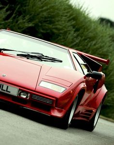 a red sports car driving down the road