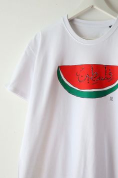 Watermelon cotton t-shirt made with screen printing 🍉. "Palestine" in Arabic calligraphy in the middle, illustration by Anis, Marseille artist. 80% of profits are donated to identified Gazan fundraisers. More info on @de.marseille.a.gaza 🇵🇸 Watermelon T Shirt, Watermelon Shirt, In Arabic, Cotton T Shirt, Watermelon, Favorite Outfit, Tee Shirt, Screen Printing, Cotton Tshirt