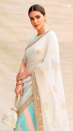 a woman wearing a white and blue sari