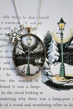 a necklace with an image of a street light and snowflakes hanging from it