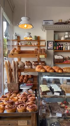 a bakery filled with lots of different types of breads and pastries on display