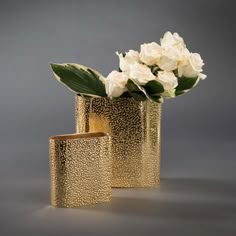 two gold vases with white flowers in them