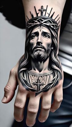 a man's hand with a tattoo of jesus holding the cross and crown on it