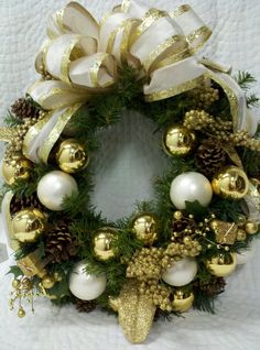 a christmas wreath with gold and white ornaments