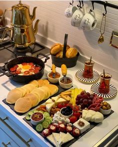 an assortment of cheeses, crackers and other food items on a kitchen counter