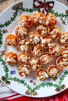 small appetizers are arranged on a plate with red and green trimmings