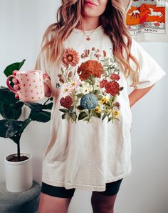 Wildflowers Comfort Colors® Shirt, Boho Wildflowers Cottagecore Shirt, Wild flowers Shirt, Gift For Women, Plant Shirts, Floral Mom Shirt ⭐️ Welcome to FlyaWay Trend Store ⭐️ Our products are BELLA+CANVAS and for Sweatshirts GILDAN quality ✨ FREE SHIPPING is for orders 35 usd and over. Enjoy 30 % OFF SALE! Please contact me for bulk (+10) orders. If you have any problems or questions, please contact me and I will be here to help. NO RETURNS OR EXCHANGES ON SHIRTS/CLOTHING ITEMS. FIT AND SIZING P Vintage White Tops With Plant Print, Cottagecore Floral Print Summer Shirt, White Botanical Floral Print T-shirt, White Botanical T-shirt With Floral Print, White T-shirt With Botanical Print, Casual White Tops With Floral Patchwork, White Floral Print T-shirt, Vintage White T-shirt With Floral Print, Cottagecore Floral Print Short Sleeve Shirt