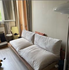 a white couch sitting next to a window in a living room