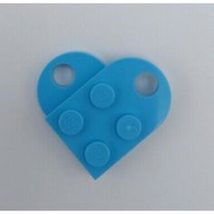 a blue heart shaped object with two holes in the shape of a puzzle piece on a white background