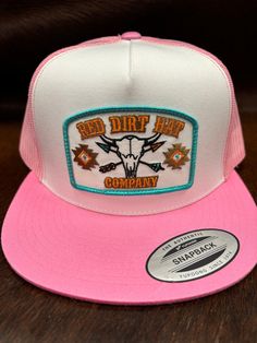 Red Dirt Hat Co. white and pink flat bill style snapback featuring the exclusive Buffalo Skull patch. Red Dirt Hat Co. is a brand for everyone. White Front Pink Mesh Back 5 Panel Red Dirt Buffalo Skull Patch Adjustable Snapback Flat Bill White Trucker Baseball Cap With Embroidered Patch, White Trucker Baseball Cap With Logo Patch, Casual Pink Hats With Logo Patch, Pink Fitted Hat With Flat Brim, White Trucker Hat With Logo Patch And Curved Brim, White Trucker Hat With Logo Patch, White Embroidered Trucker Hat, Pink Flat Brim Trucker Hat, Casual Pink Snapback Hat With Flat Bill