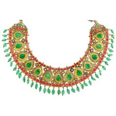 Indian Gold, Foil-Backed Emerald, Ruby and Synthetic Ruby and Diamond, Emerald Bead and Jaipur Enamel Fringe Necklace. The curved bib centering 13 pear-shaped foil-backed emeralds, within pear-shaped frames decorated with oval green enamel spades, spaced by pairs of foil-backed vari-shaped table-cut diamonds, edged by lines of cushion-shaped foil-backed rubies and rubies, tipped by rondels applied with red enamel, suspending oval emerald beads, reverse with red, white, green and blue floral enam Traditional Formal Jewelry With Historical Design, Antique Kundan Meenakari Necklace, Antique Kundan Temple Necklace For Ceremonial Use, Antique Kundan Temple Necklace For Ceremonial Occasions, Antique Kundan Necklaces For Festivals, Antique Kundan Temple Necklace, Traditional Jeweled Bridal Necklace For Ceremonial Occasion, Traditional Wedding Necklace With Historical Design, Antique Necklaces For Formal Festivals