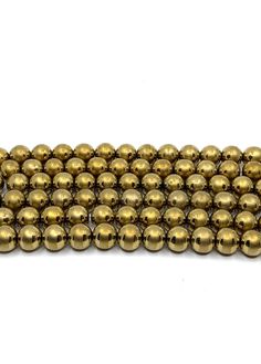 brass plated round beads on white background