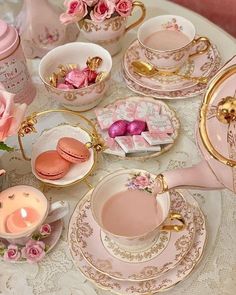 a table topped with pink tea cups and saucers