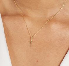 The 14K Solid Gold Small Cross Necklace is a symbol of faith, devotion, and timeless elegance. Crafted with meticulous attention to detail, this delicate piece features a tiny cross pendant made from 14K solid gold. Its simple yet profound design makes it a perfect religious necklace for women, suitable for various occasions such as baptisms, weddings, or as a thoughtful Mother's Day or birthday gift. As a symbol of one's faith and commitment, this cross necklace holds deep significance. It serves as a reminder of one's beliefs and values, offering strength, comfort, and inspiration to the wearer. Whether worn as a daily expression of spirituality or on special occasions to mark significant milestones, this necklace carries with it the blessings and well-wishes of the giver. For a bride, t 14k Gold Cross Necklaces For Baptism, Dainty Cross Pendant Jewelry For First Communion, 14k Gold Cross Necklace For Baptism, Classic Cross Pendant Jewelry For First Communion, Classic Yellow Gold Jewelry For First Communion, Classic Crucifix Jewelry For First Communion, Classic Cross Jewelry For Baptism, Classic Cross Necklace For Baptism, Classic 14k Gold Jewelry For First Communion