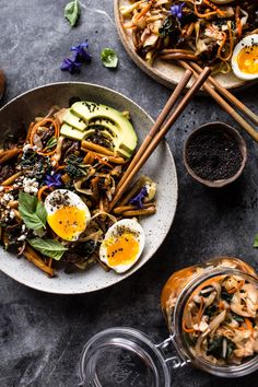 two bowls filled with food and chopsticks next to each other on a table