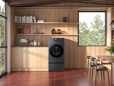 a washer sitting in the middle of a kitchen next to a table and chairs