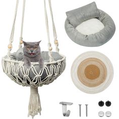 a gray cat sitting in a hammock with accessories including a hat, rug and ear hooks