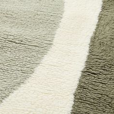 an area rug with different colors and patterns on it, including white, green, gray and black