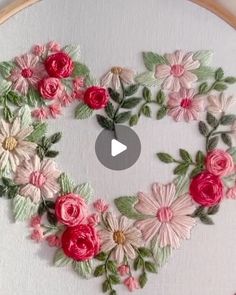 an embroidered heart with pink and red flowers