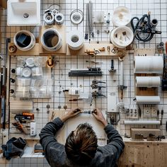 A person working on a DIY industrial bathroom project, surrounded by tools, pipes, and various materials3