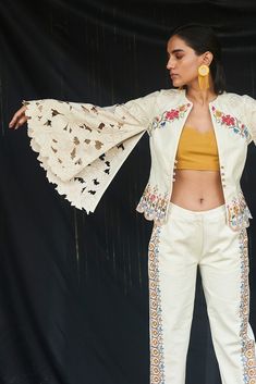 Editor's Note Featuring an ivory cutwork short jacket with cape sleeve with kala cotton embroidered pants. Color: Ivory Fabric: Kala Cotton Care: Dry Clean Only About the Designer Chandrima celebrates diversity in cultures and craft forms creating ready-to-wear women wear for the urban woman of today. The brand embodies the idea of Indian handloom and craft merged with an international style. Label Chandrima stands for modern elegance and craftsmanship stemmed from the diversity and unity of the Short Jacket Outfit, Simple Kurtis, Cape Designs, Denim Maxi Dress, Ivory Fabric, Western Tops, Embroidered Pants, Simple Pakistani Dresses, Denim Maxi