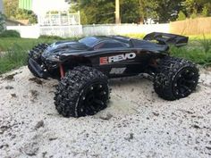 a toy truck that is sitting on the ground in the sand with its wheels off