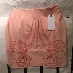 Peach-Color Skirt With Floral Design Embroidered In Orange Thread. Bottom Part Of Design Is Cut Out To Reveal Skin. Very Cute! Spring Pencil Skort With Lined Skirt, Pink Relaxed Fit Pencil Skirt For Summer, Spring Floral Embroidered Mini Skirt For Party, Fitted Floral Embroidered Mini Skirt For Spring, Embroidered Pink Skirt For Summer, Fitted Floral Embroidered Mini Skirt For Summer, Pink Embroidered Skirt, Summer Embroidered Pink Skirt, Fitted Pink Embroidered Skirt