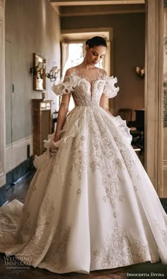 a woman in a white wedding dress is looking down at the floor with her hand on her hip