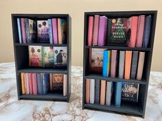 two bookshelves that have different types of books in them on top of a bed