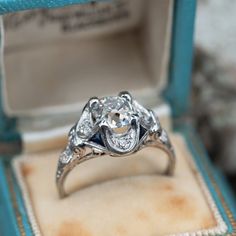 an antique style diamond ring in a blue box