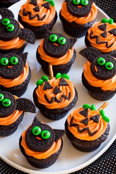 cupcakes decorated with orange frosting and green sprinkles on a white plate