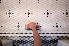 a person is using a tile grouter on the wall