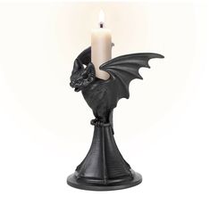 a black candle holder with a dragon on it's side and a lit candle in the middle