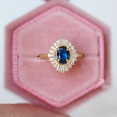 Beautiful Art Deco Sapphire Ring ►Base Metal: Sterling Silver (S925) ►Plating: 14K Yellow Gold Vermeil ►Accented With Simulated Diamonds Main Stone: Sapphire Color: Blue Gemstone Creation: Lab-Created Stone Shape: Oval Cut Gem size: 7.0 x 5.0 mm Carat Weight: 0.76 ct. (Approx.) ►Can be customized. Please contact us if you have special requests. ►Please be aware that plated jewelry can wear off over time, if this is a concern we would suggest going with the sterling silver or solid gold jewelry o Sapphire Cluster Ring In 14k Gold For Wedding, Sapphire Cluster Ring 14k Gold For Wedding, Vintage Blue Diamond Ring For Wedding, Vintage Blue Diamond Wedding Ring, Heirloom Blue Sapphire Ring For Wedding, Heirloom Blue Cluster Ring With Center Stone, Blue Sapphire Ring In 14k Gold For Wedding, Blue Cluster Ring With Halo Setting For Wedding, Blue Cluster Ring With Halo For Wedding