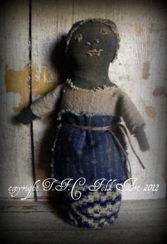 an old doll is sitting on a wooden surface