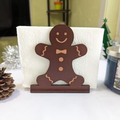 a wooden ginger standing on top of a table next to a pine cone and candle holder