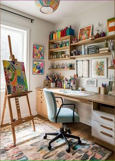 a desk with an easel on it in front of a window and shelves filled with art supplies