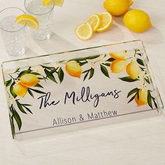 personalized glass placemats with lemons and leaves on them, along with two glasses