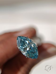 a person holding a blue diamond in their hand