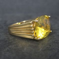 This gorgeous vintage ring is gold vermeil over sterling silver with a 12x15mm yellow cubic zirconia. The face of this ring measures 1/2 of an inch north to south with a rise of 10mm off the finger. Size: 6 Marks: 925 condition: Excellent Classic Gold Citrine Rings, Classic Yellow Rings With Center Stone, Classic Yellow Ring With Center Stone, Classic Yellow Topaz Ring For Promise, Classic Yellow Topaz Promise Ring, Classic Yellow Topaz Ring With Center Stone, Elegant Yellow Hallmarked Signet Ring, Elegant Yellow Signet Ring For Formal Occasions, Gold Heirloom Topaz Ring With Prong Setting