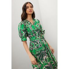 Green floral (100% Cotton). Casual dress. Short sleeves. V-neck. Tie closure. 53" from shoulder to hemline. Imported. V-neck Printed Floral Dress For Garden Party, Green V-neck Wrap Dress For Spring, Summer Midi Dress With Floral Print And Notched Neckline, Tropical Print V-neck Midi Dress For Garden Party, Chic V-neck Midi Dress With Tropical Print, Spring V-neck Floral Print Dress With Notched Neckline, Chic Green V-neck Floral Dress, Spring Floral Print Dress With Notched Neckline, Chic V-neck Dress With Notched Neckline And Floral Print